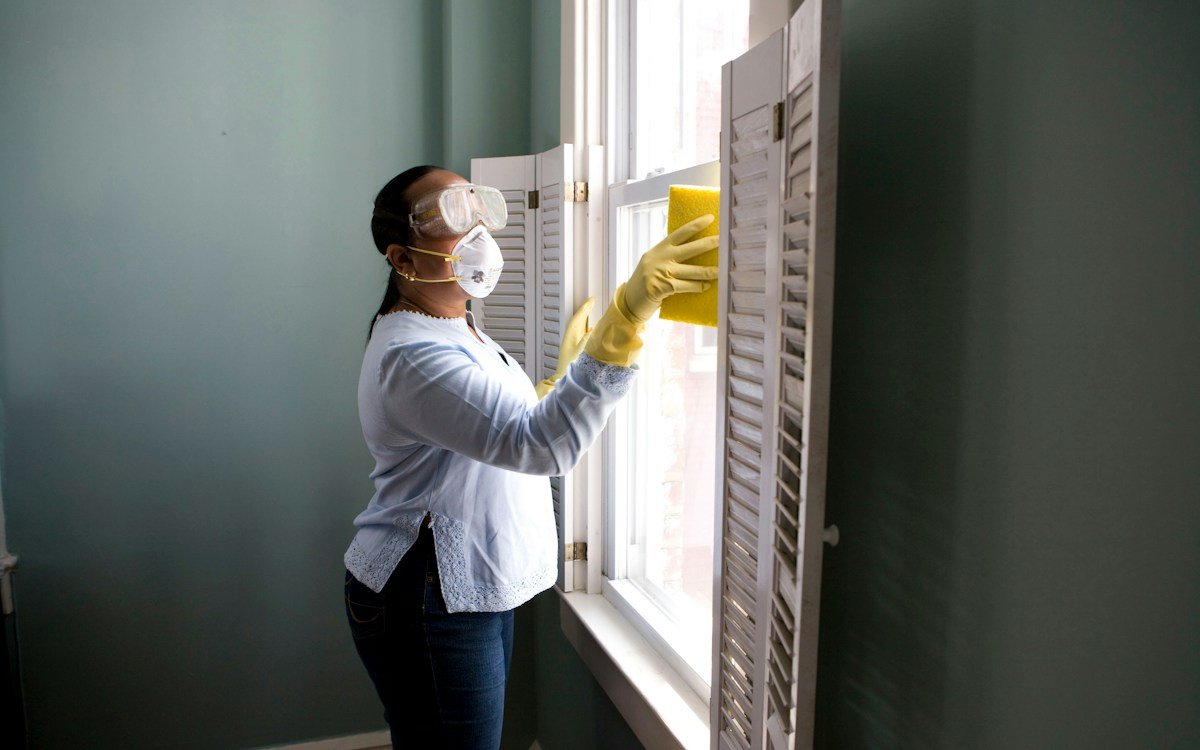 Professional commercial cleaning technician sanitizing high-touch communal surfaces and handrails with microfiber technology